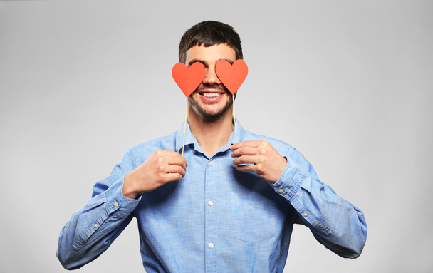 man holding red hearts near eyes - Фото, изображение