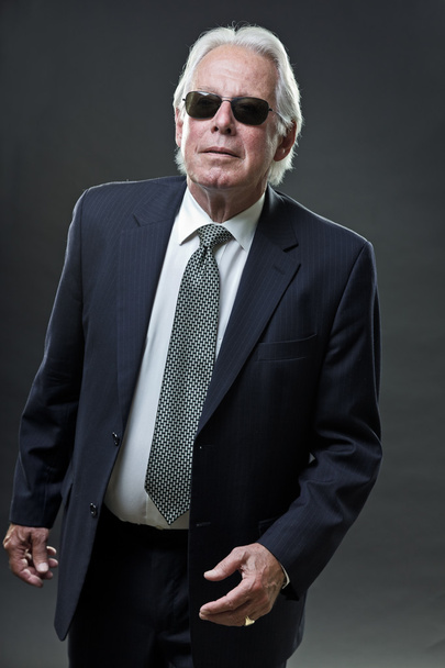 Senior business man with sunglasses isolated on grey background. - Photo, Image
