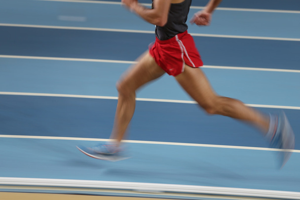 Atletas descoloridos corren en pista y campo
 - Foto, imagen