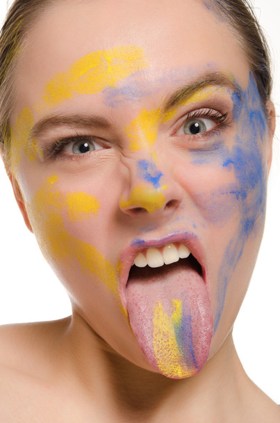 Woman with paint on his face shows tongue - Foto, imagen