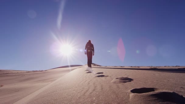 Nainen tutkimusmatkailija kävelee hiekkadyynit
  - Materiaali, video