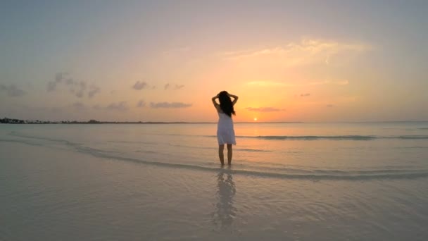 Chica china en vestido blanco bailando en la playa
 - Imágenes, Vídeo