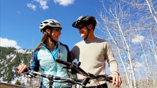 屋外でサイクリングを楽しむ若いカップル - 映像、動画