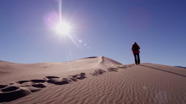 explorador mujer caminando a través de dunas de arena
  - Imágenes, Vídeo