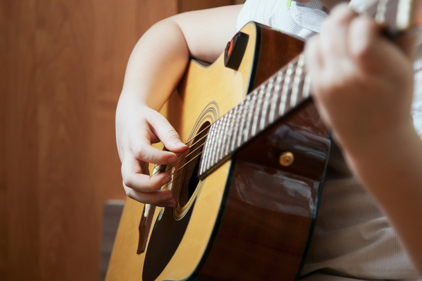 Little boy is playing the guitar - Фото, изображение