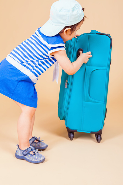 Child packs her things, clothes at luggage - Foto, Imagem