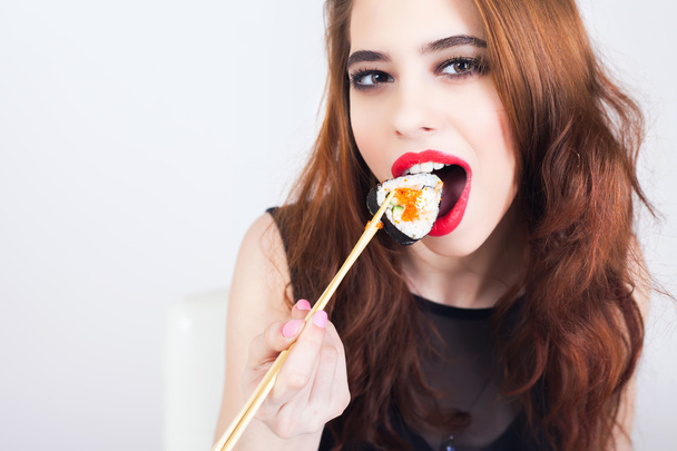 Fiatal nő enni sushi, japán étterem  - Fotó, kép