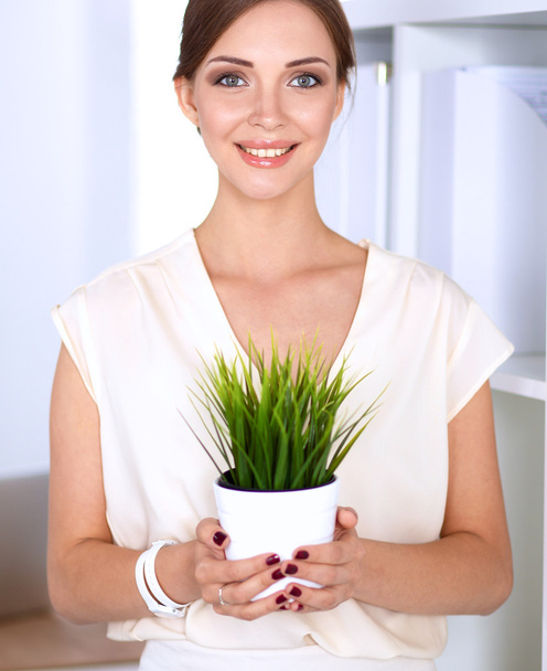 Beautiful woman holding pot with a plant - Fotoğraf, Görsel