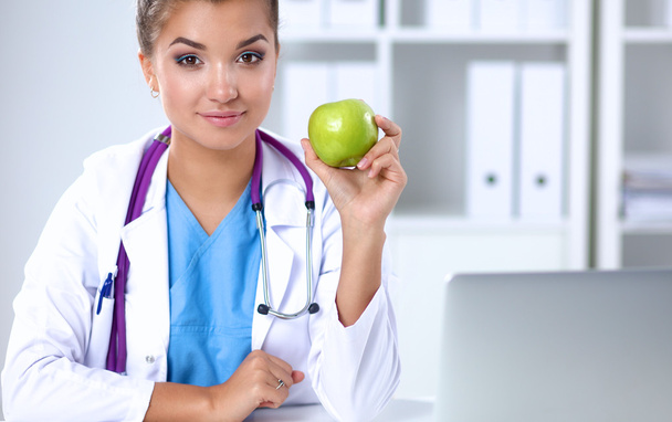 Female doctor hand holding a green apple - Photo, image
