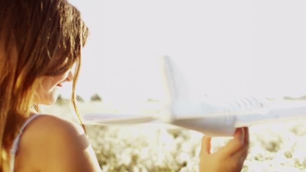 Νεαρό κορίτσι παίζει με αεροπλάνο παιχνίδι - Πλάνα, βίντεο