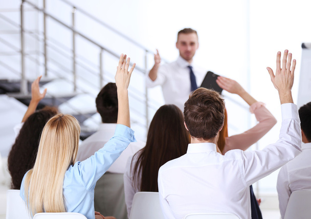 colleagues raising hands at the business meeting - Фото, изображение