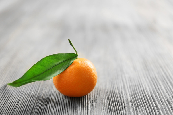 Fresh tangerine with leaf on wooden table, closeup - Foto, Bild