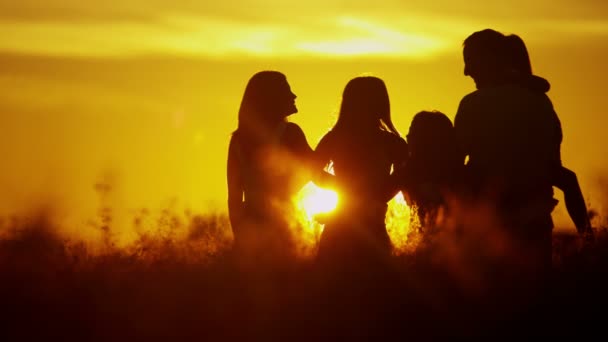 ouders met dochters op weide bij zonsondergang - Video