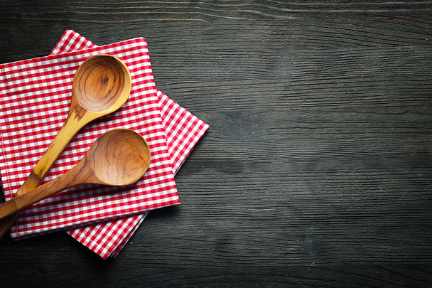 Checkered napkin and spoons on wooden background - Fotó, kép