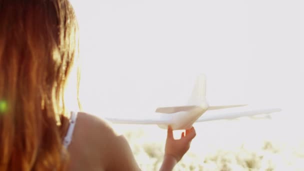 Νεαρό κορίτσι παίζει με αεροπλάνο παιχνίδι - Πλάνα, βίντεο