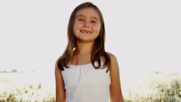 uśmiechnięta młoda dziewczyna na zewnątrz w łące - Materiał filmowy, wideo