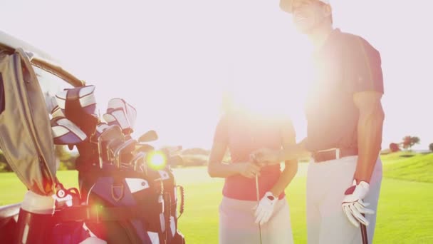 Graczy płci męskiej i żeńskiej golfa na polu golfowym - Materiał filmowy, wideo