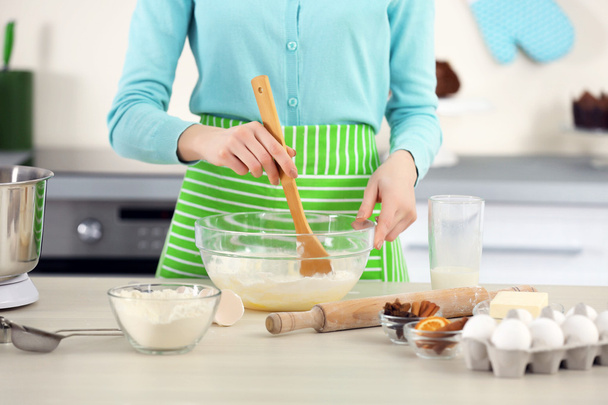 Young woman mixing dough in a bowl - Φωτογραφία, εικόνα