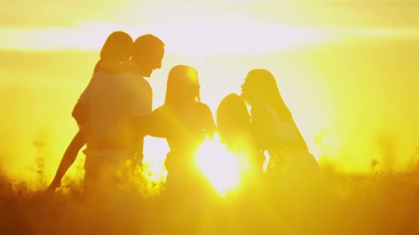ouders met dochters op weide bij zonsondergang - Video