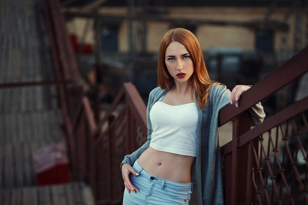 Beautiful redhair young woman in casual closes in urban background. Fashion Photo - Photo, Image