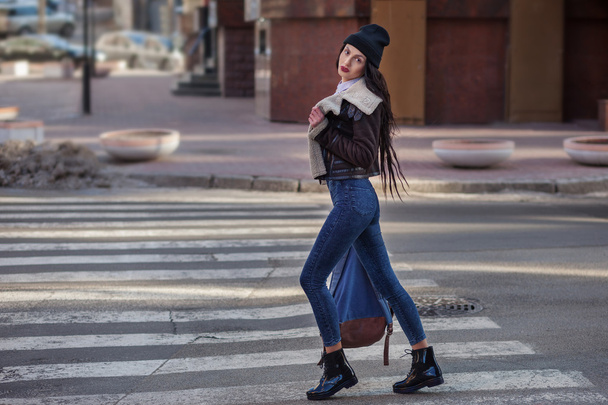 Портрет красивої молодої дівчини на відкритому повітрі, в стилі хіпстерського бондура на міському тлі. Носіть капелюх і джинси з рюкзаком. Весняна жінка моди. Фільтри тонованого стилю Instagram
. - Фото, зображення