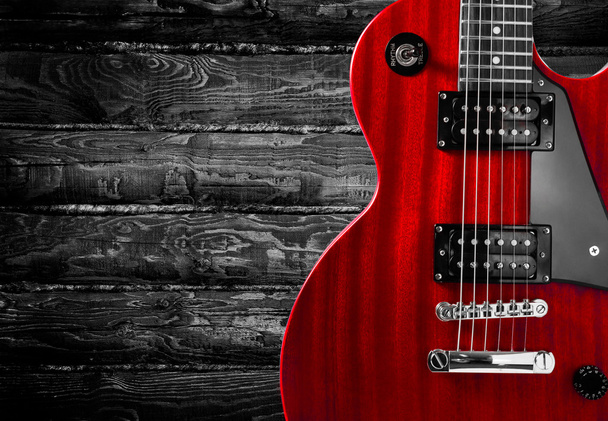 Část červené elektrická kytara na dřevěné pozadí. Místo pro psaní textu. - Fotografie, Obrázek