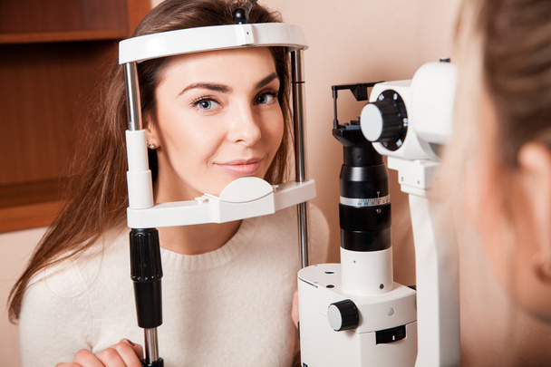 Lovely Young adult woman is having eye exam performed by eye doc - Φωτογραφία, εικόνα