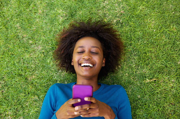 Śmiejąc się kobieta, leżąc na trawie - Zdjęcie, obraz