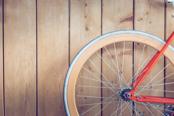 bicicleta estacionada con pared de madera, cerca de la imagen parte de la bicicleta
 - Foto, Imagen