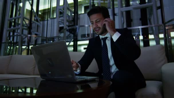 podnikatel, práci s notebookem a chytrý telefon v noci - Záběry, video