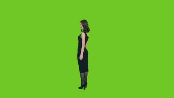Mädchen in schwarzem Kleid auf grünem Hintergrund - Filmmaterial, Video