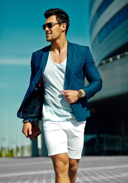 High fashion look.Young stylish confident happy handsome  businessman model man in blue suit cloth lifestyle in the street in sunglasses behind sky - Фото, зображення