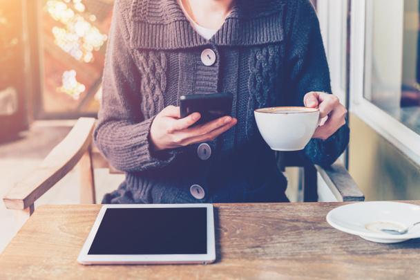 женщина с помощью смартфона в кафе и мягкий свет
 - Фото, изображение