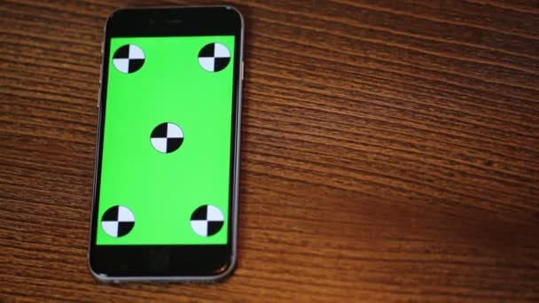 Colpo in testa di smartphone con schermo verde su un tavolo di legno con spazio copia Vista dall'alto
 - Filmati, video