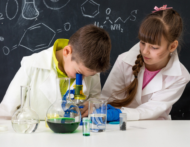 two schoolchildren watching chemical experiment - Photo, image