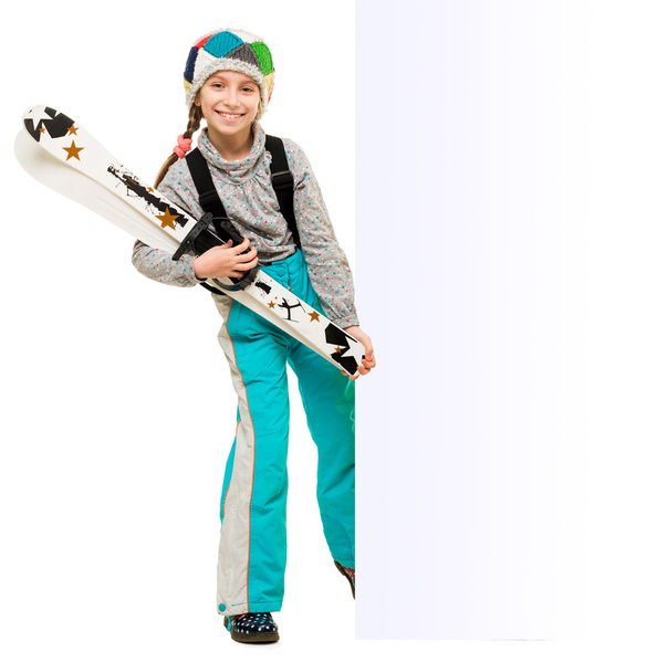Маленькая девочка с лыжами указывает на пустой холостой
 - Фото, изображение