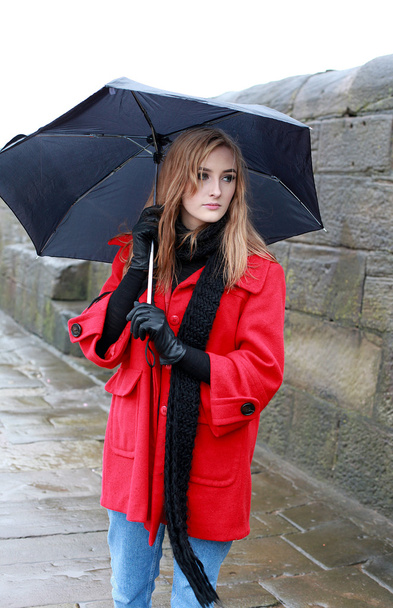 junge Frau mit Regenschirm vor Schneeregen und Regen - Foto, Bild