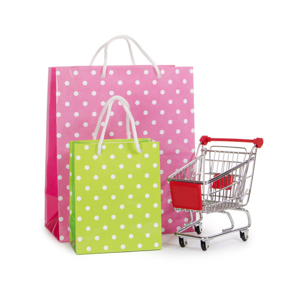 The shopping cart and bags isolated on white - Фото, изображение