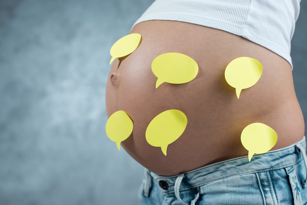 Close-up van een schattige zwangere buik en stickers erop. Zwangere f - Foto, afbeelding
