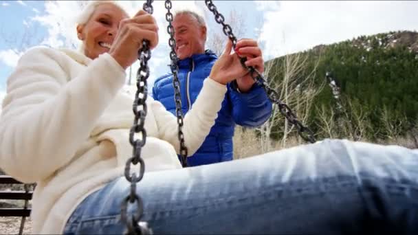 Senior paar swingen op een schommel op buiten - Video