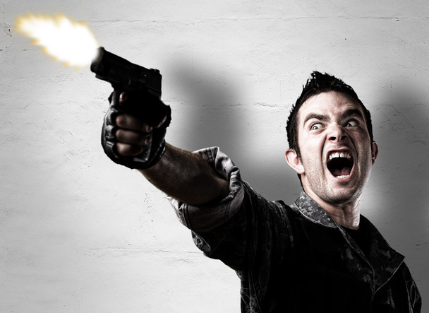Człowiek strzelający pistoletem - Zdjęcie, obraz