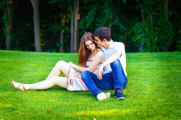 Liefhebbers van man en vrouw zittend op het gras - Foto, afbeelding
