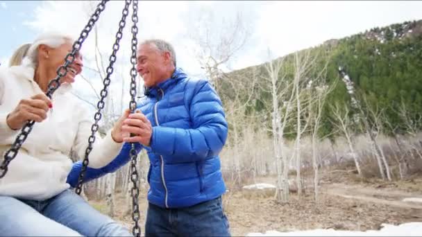 starší pár, houpání na houpačce na venkovní - Záběry, video