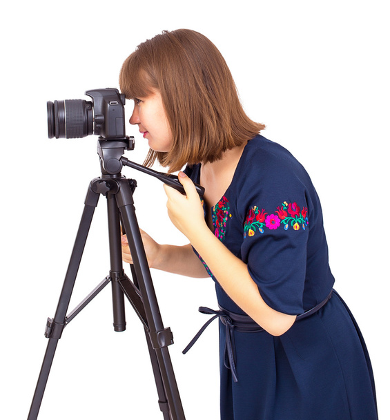 Mujer fotógrafa mirando en la lente de la cámara en un trípode
 - Foto, imagen