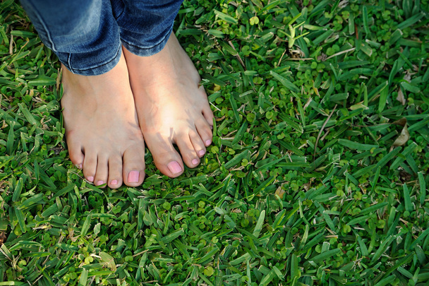 blote voet op groen gras - Foto, afbeelding