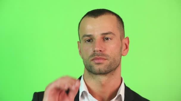 Een man op een groene achtergrond close-up - Video
