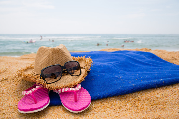 Καπέλο, γυαλιά ηλίου και άλλα στοιχεία σε μια παραλία - Φωτογραφία, εικόνα
