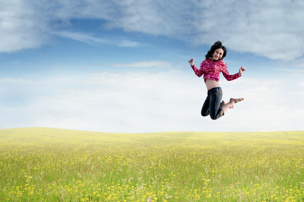 Mujer asiática salta en la naturaleza
 - Foto, Imagen