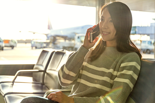 nő beszél a mozgatható telefon-nél repülőtér - Fotó, kép