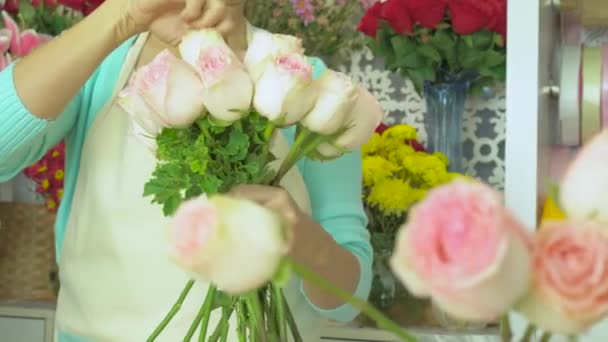Kwiaciarnia, kwiaciarnia układanie różowy bukiet róż - Materiał filmowy, wideo